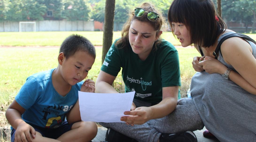 A young boy learns how to correctly pronounce English words while working with a Project Abroad volunteer teaching English in China A Teaching volunteer in China helps her student learn the lines of an English play